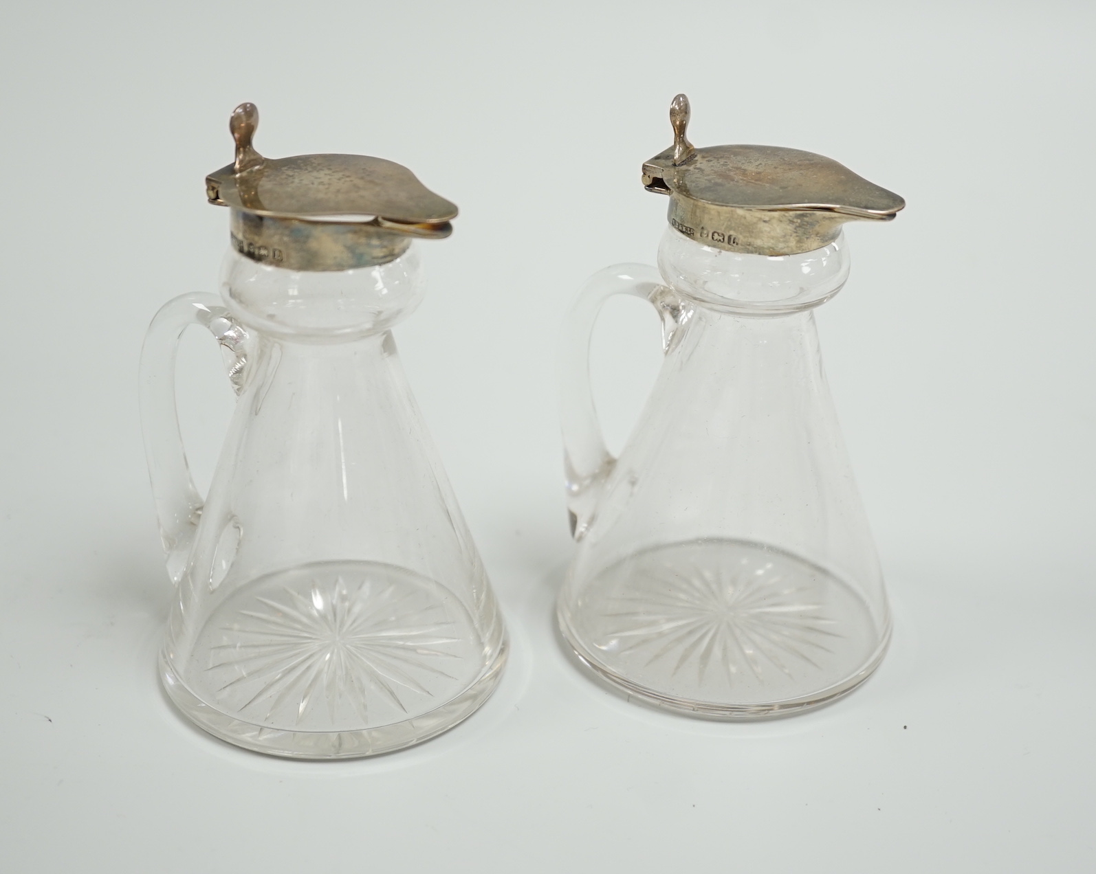 A cased pair of George V silver mounted glass whisky noggins, S. Blanckensee & Sons Ltd, Birmingham, 1935, 10.5cm.